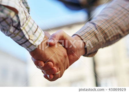 a businesspeople shaking hands, making an agreement. a businesspeople shaking hands, making an agreement. 43869929