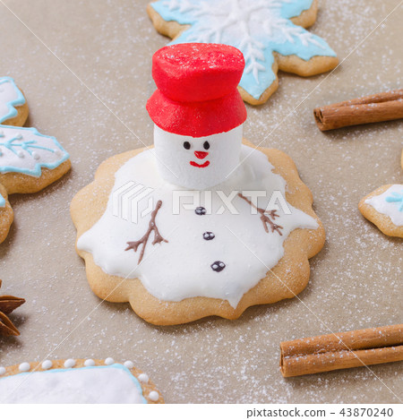 christmas gingerbread like melting snowman, snowflakes and flour like snow on the baking paper christmas gingerbread like melting snowman, snowflakes and flour like snow on the baking paper 43870240