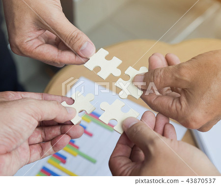 Group of business people assembling jigsaw puzzle Group of business people assembling jigsaw puzzle 43870537