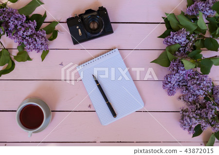 on the white table lilac, gift, notebook, cup of tea 43872015