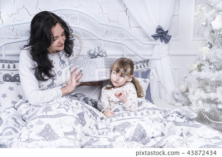 Child listens to a box with gift Child listens to a box with gift 43872434