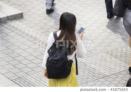 後面觀點的少婦走的智能手機 43875843