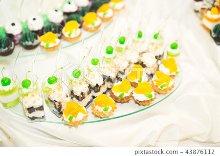 Delicious sweets on wedding candy buffet with desserts, cupcakes Delicious sweets on wedding candy buffet with desserts, cupcakes 43876112