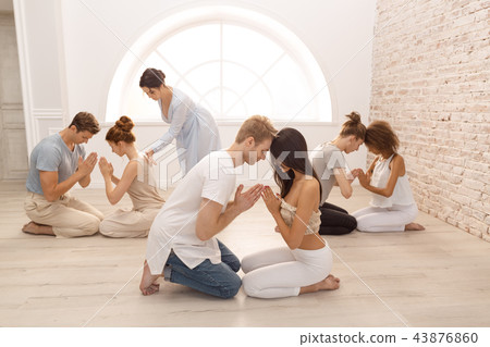 Group of people meditating indoors. Young family therapy Group of people meditating indoors. Young family therapy 43876860