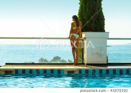 sexy girl by the pool overlooking the ocean 43878392