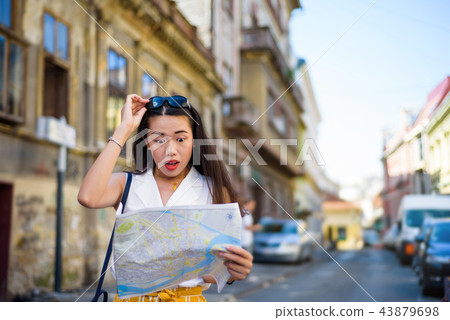 Asian traveler with a map exploring city streets 43879698