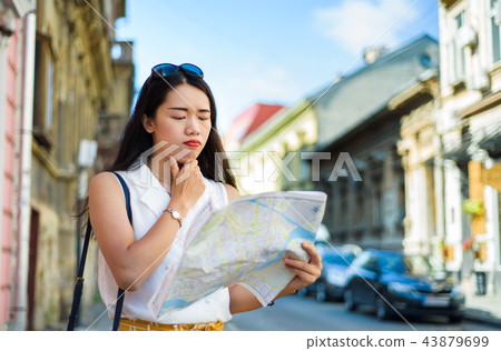Asian traveler with a map exploring the city streets Asian traveler with a map exploring the city streets 43879699