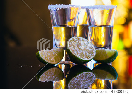 stack of tequila with salt close up on background 43880192