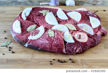 Raw beef meat with laurel leaves, black peppercorns and onion sl Raw beef meat with laurel leaves, black peppercorns and onion sl 43880300