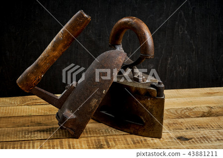 two old rusty iron on a bright wooden table 43881211