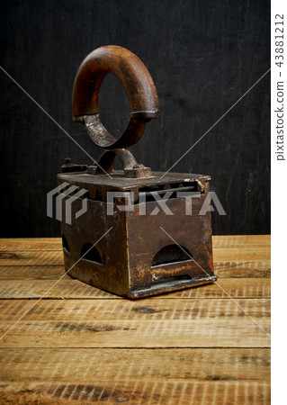 vintage old rusty iron on a bright wooden table vintage old rusty iron on a bright wooden table 43881212