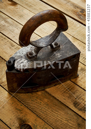 vintage old rusty iron on a bright wooden table vintage old rusty iron on a bright wooden table 43881237