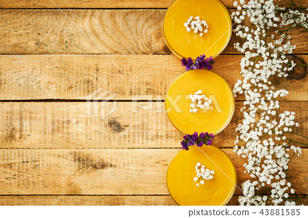 delicious pumpkin soup and flowers on an old wooden kitchen table 43881585