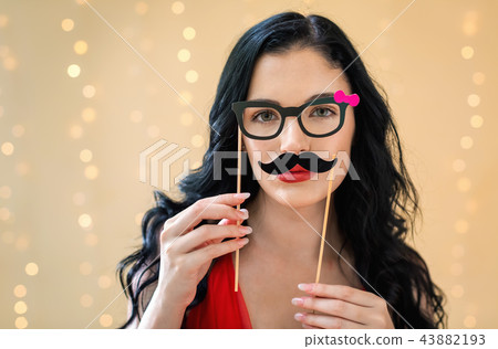 Young woman with paper glasses and mustache sticks Young woman with paper glasses and mustache sticks 43882193