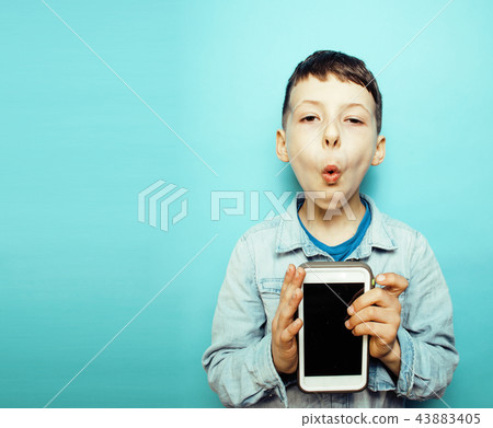little cute boy posing emotional on blue background with smartph little cute boy posing emotional on blue background with smartph 43883405