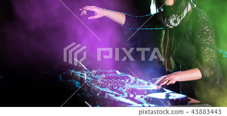 Dj mixes the track in the nightclub at a party Dj mixes the track in the nightclub at a party 43883443