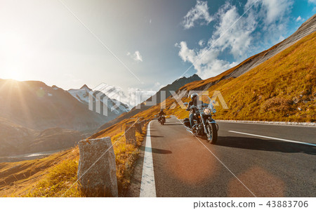 Motorcycle driver riding japanese high power cruiser in Alpine highway on famous Hochalpenstrasse, Austria. 43883706