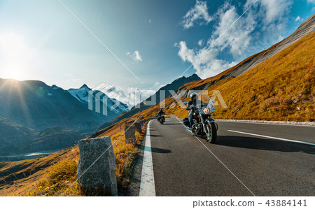 Motorcycle driver riding in Alpine highway on famous Hochalpenstrasse, Austria, Europe. Motorcycle driver riding in Alpine highway on famous Hochalpenstrasse, Austria, Europe. 43884141