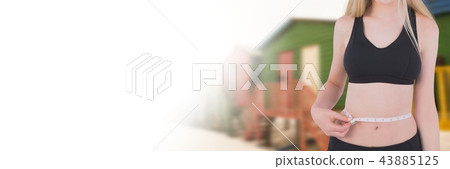 Woman measuring weight with measuring tape on waist near summer beach huts with transition 43885125