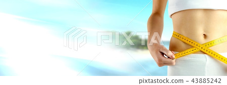Woman measuring weight with measuring tape on waist on tropical paradise Summer beach with transitio Woman measuring weight with measuring tape on waist on tropical paradise Summer beach with transitio 43885242