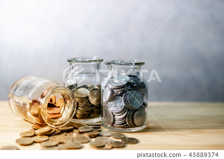 Coin in glass jars. Saving money for retirement Coin in glass jars. Saving money for retirement 43889374