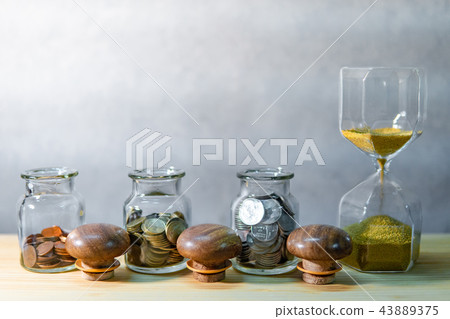 Coin jars and hourglass. Save money for retirement Coin jars and hourglass. Save money for retirement 43889375