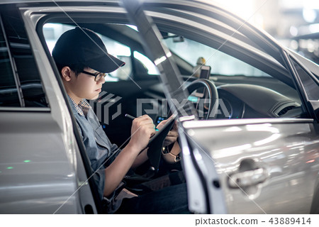 Asian auto mechanic checking the car using tablet 43889414