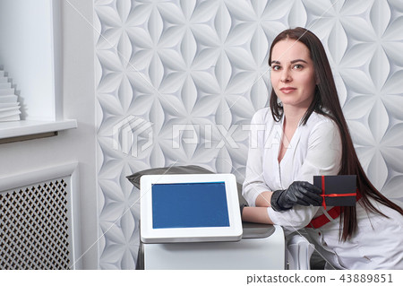 cosmetologist with IPL cosmetology device. Hair laser removal service. Cosmetic LED laser device for cosmetologist with IPL cosmetology device. Hair laser removal service. Cosmetic LED laser device for 43889851