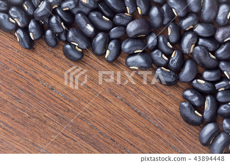 black bean on wooden table. top view. 43894448