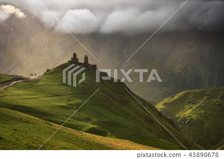 Sunrise at the Gergeti Trinity Church with sunrays of Kazbegi mountain in Georgia 43898678