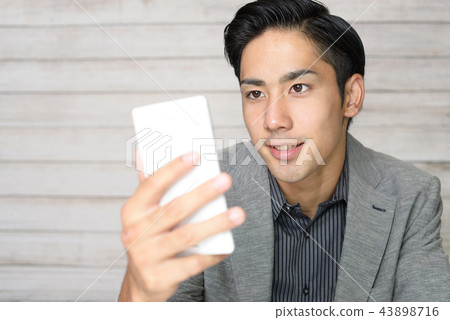 有智能手機的一個微笑的人 有智能手機的一個微笑的人 43898716