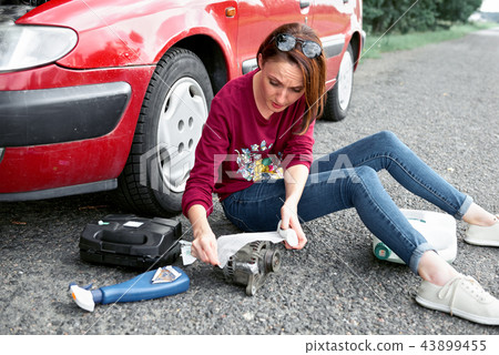 young girl sitting on the road by the red car young girl sitting on the road by the red car 43899455