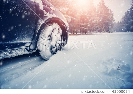 Car tires on winter road covered with snow Car tires on winter road covered with snow 43900054