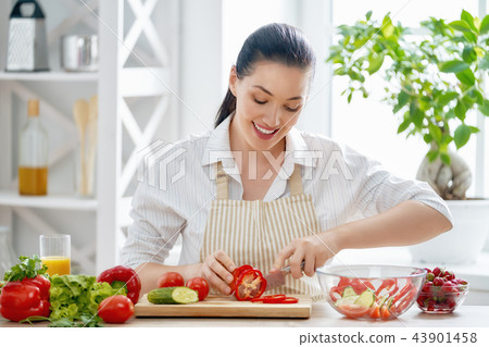woman is cooking vegetables woman is cooking vegetables 43901458