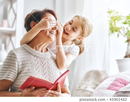 Grandmother reading a book to granddaughter 43901482