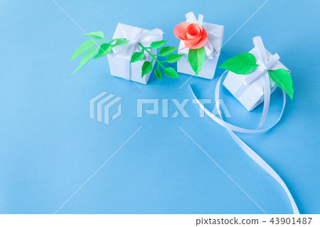 white gift with paper flower on blue background white gift with paper flower on blue background 43901487
