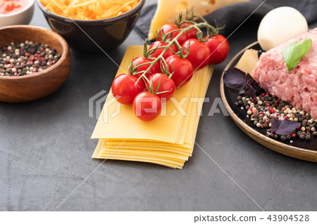 Ingredients for Italian lasagna with fresh cherry tomatoes and green basil leaves on sheets of dried Ingredients for Italian lasagna with fresh cherry tomatoes and green basil leaves on sheets of dried 43904528