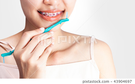 woman is wearing braces and using a cleaning 43904697