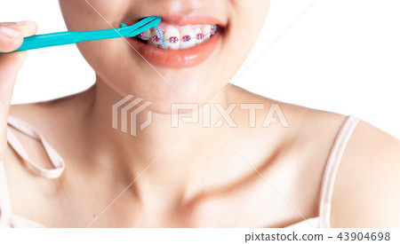 A woman is using a cleaning teeth. 43904698