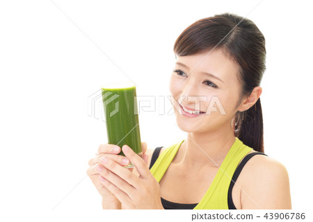 A woman drinking vegetable juice 43906786
