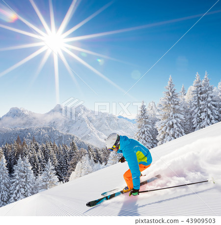 Skier skiing downhill in high mountains Skier skiing downhill in high mountains 43909503