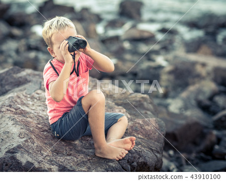 Little boy looking far away with binoculars 43910100