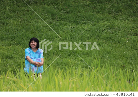 Bright mature woman shines in green park 43910141