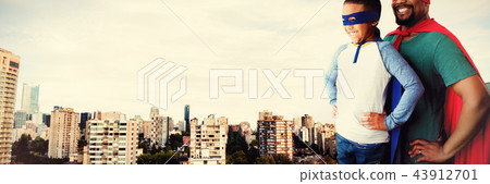 Composite image of father and son pretending to be superhero 43912701
