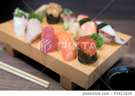 Close-up sushi and sashimi mixed on wooden plate Close-up sushi and sashimi mixed on wooden plate 43912820