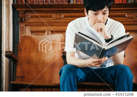 A man reading a book in a library 43913206