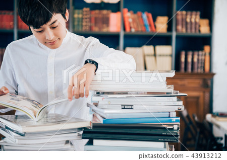 A man reading a book in a library 43913212