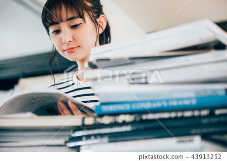 讀一本書的婦女在圖書館裡 讀一本書的婦女在圖書館裡 43913252