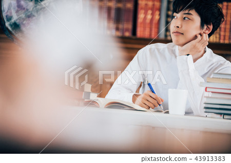 A man reading a book in a library A man reading a book in a library 43913383
