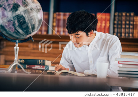讀一本書的一個人在圖書館裡 43913417